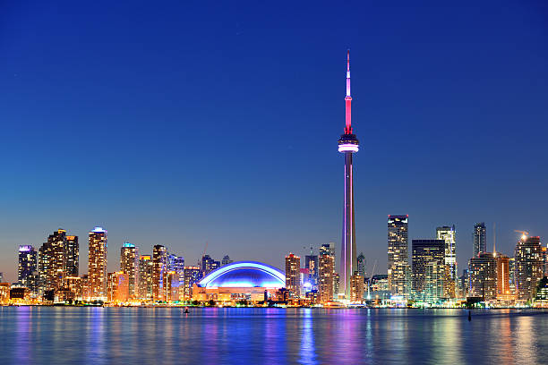 Toronto skyline with CN Tower at night - beautiful city lights reflecting on Lake Ontario